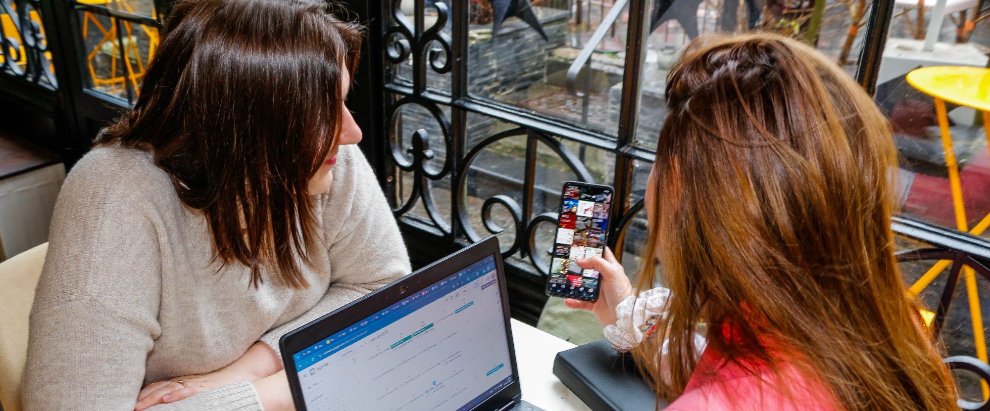 Coach digital montrant une stratégie Instagram à une entrepreneure en formation.